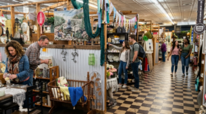 Customers browsing vendor booths inside a busy antique mall marketplace