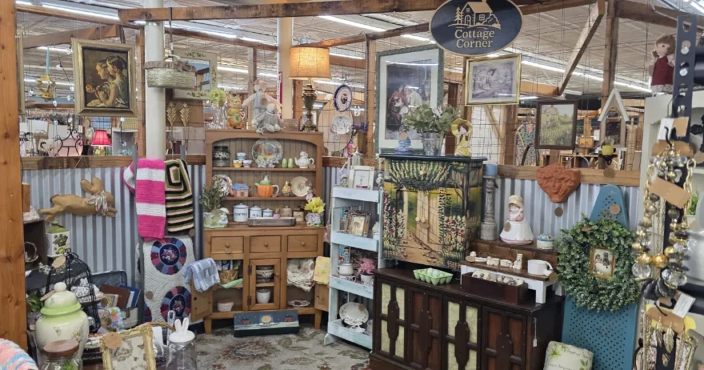 Antique mall booth filled with vintage inventory including glassware, decor, and collectibles displayed on shelves