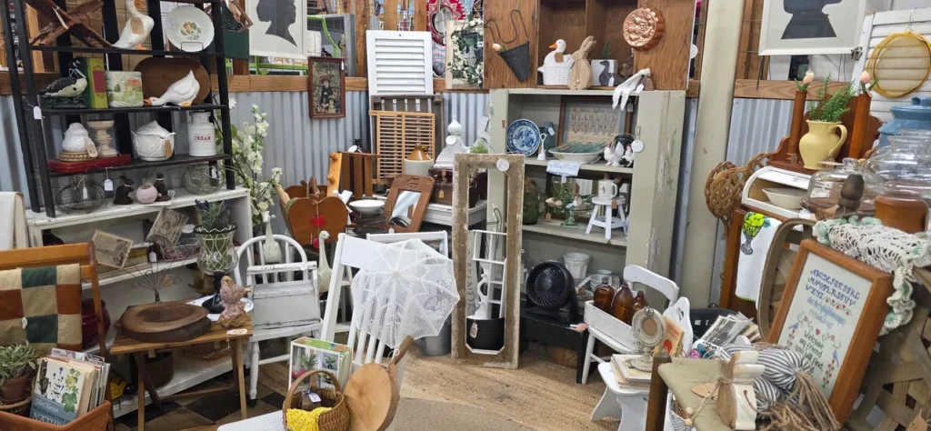 Well-designed antique mall booth display with shelves, vintage decor, and layered merchandise arrangement