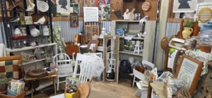 Well-designed antique mall booth display with shelves, vintage decor, and layered merchandise arrangement